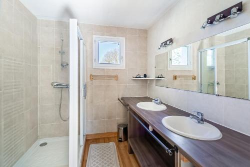 un bagno con due lavandini e una doccia di Grande maison familiale à 230m de la plage ! a Planguenoual