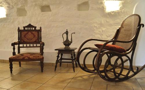 a group of chairs and a table and a clock at Lithos Stone Suites in Areopolis