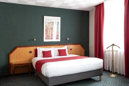 a bedroom with a large bed with red curtains at Hotel De La Paix in Lille