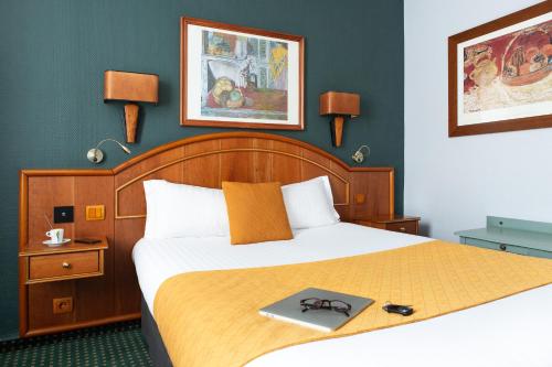 a hotel room with a bed with a tray on it at Hotel De La Paix in Lille