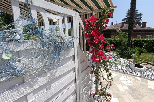 a white fence with flowers on the side of it at Guesthouse Villa Stanger 2 in Lovran