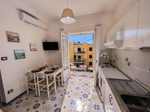 a kitchen with a table and a view of a building at Nido del Sole Ischia in Ischia