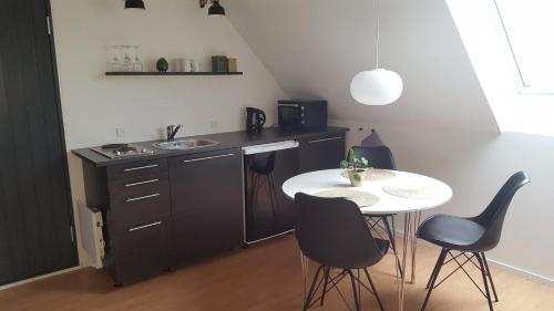 una cucina con tavolo, sedie e lavandino di Elleholm A a Odense