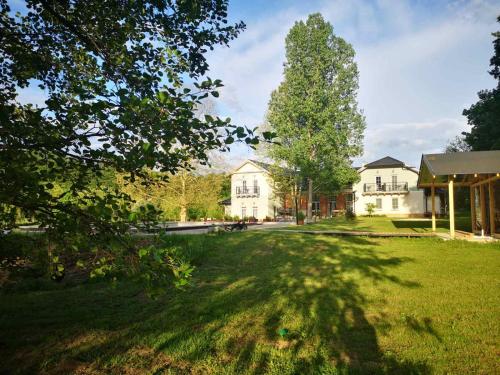 a large yard with a house and a tree at Varga Villa in Orfű