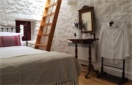 a bedroom with a bed and a shelf and a ladder at Lithos Stone Suites in Areopolis