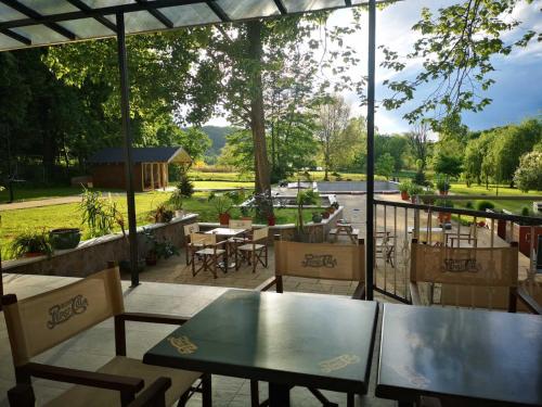 a patio with tables and chairs and a view of a garden at Varga Villa in Orfű