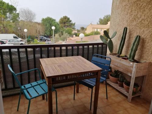 uma mesa e cadeiras numa varanda com um cacto em Sanary les gorguettes, studio avec terrasse vue mer, à 10 min à pieds de la plage em Sanary-sur-Mer