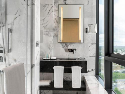 a bathroom with a sink and a mirror at WestSide Residences by Rotana in Istanbul