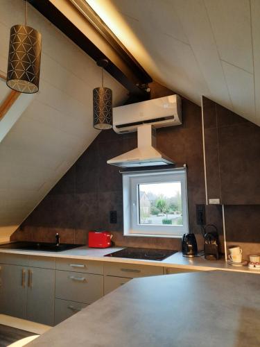 een keuken met een wastafel en een fornuis top oven bij Studio neuf côté campagne agréable à vivre. in Braine-le-Comte