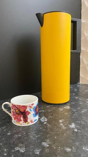 een gele kan en een koffiekopje op een aanrecht bij Fishermans Beach Suites & Rooms Albufeira in Albufeira