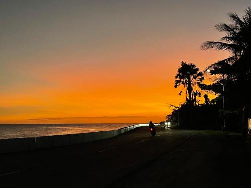 a person riding a bike on the beach at sunset at D' Partner's Inn in Jagna