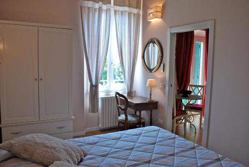 Schlafzimmer mit einem Bett, einem Schreibtisch und einem Spiegel in der Unterkunft Piccolo Navy in Livorno