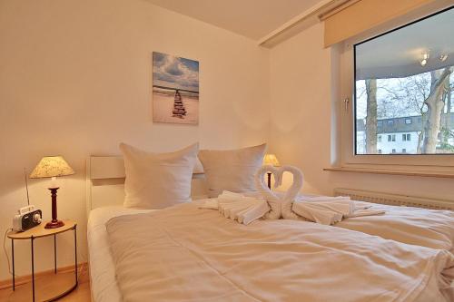 a bedroom with a large white bed with swans on it at Haus Hubertus Haus Hubertus Appartement 05 in Niendorf