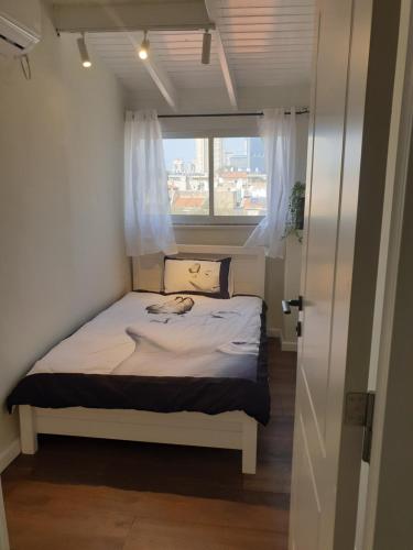 a small bed in a small room with a window at LUXURY PENTHOUSE GREAT LOCATION WITH PARKING Tlv in Ramat Gan