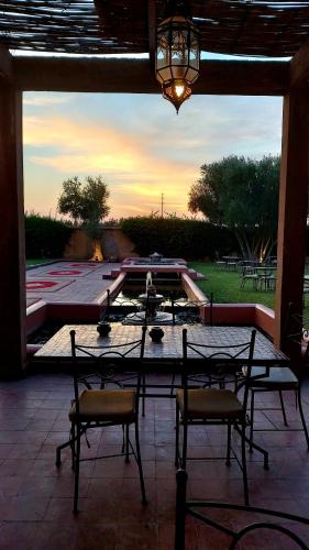 a patio with two chairs and a table with a ping at La Maison Des Oliviers in Marrakesh