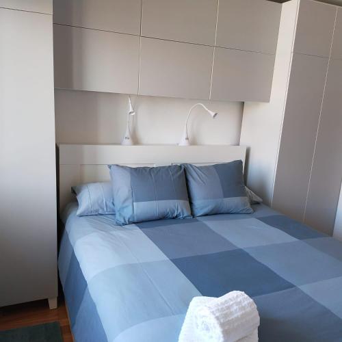 a blue bed with blue pillows in a room at Duplex a 25 metros de la playa in Somo