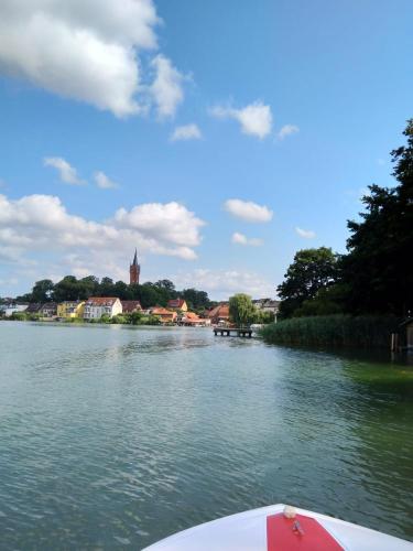 a boat on a river with a town in the background at Ferienwohnung Familie Windt in Feldberg