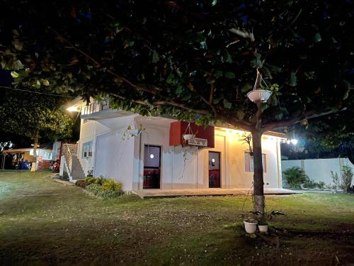 a small white house with a tree in the yard at D' Partner's Inn in Jagna