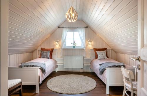 two beds in a attic bedroom with a window at Villa Wasserkreuz in Wandlitz