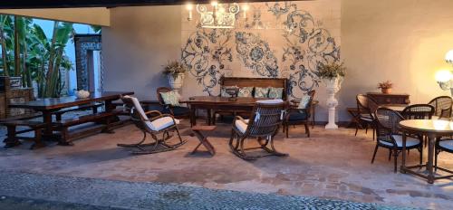 a dining room with chairs and tables and a wall at Alquería Calatrava B&B in Burriana