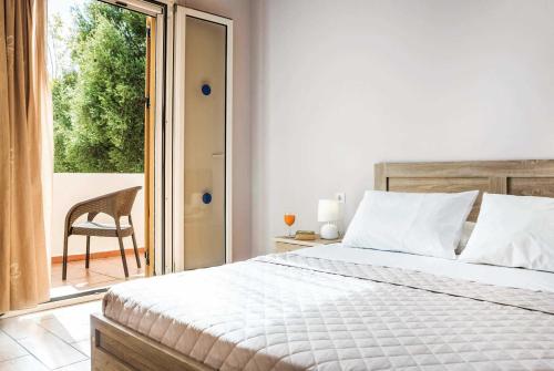 カテリオスにあるAlexandra Katelios Kefaloniaのベッドルーム1室(ベッド1台、椅子、窓付)