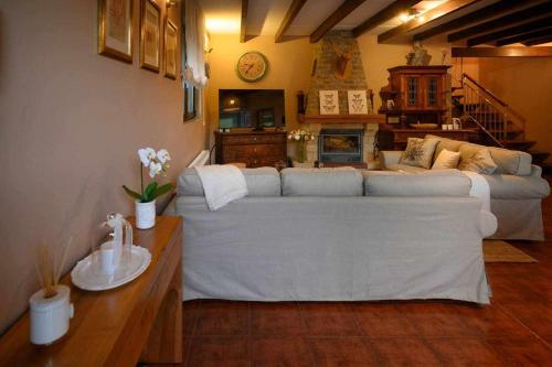 a living room with a white couch and a table at Casa rural la castañona in Buiza