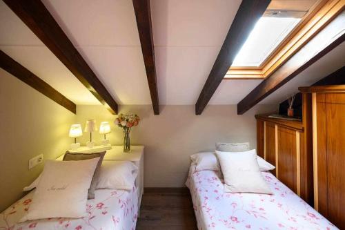 a bedroom with two beds in a attic at Casa rural la castañona in Buiza