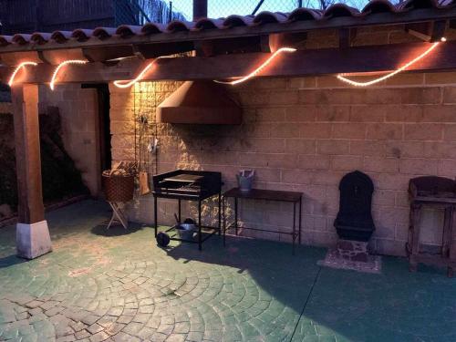 a patio with a brick wall with a grill and a stove at Casa rural la castañona in Buiza