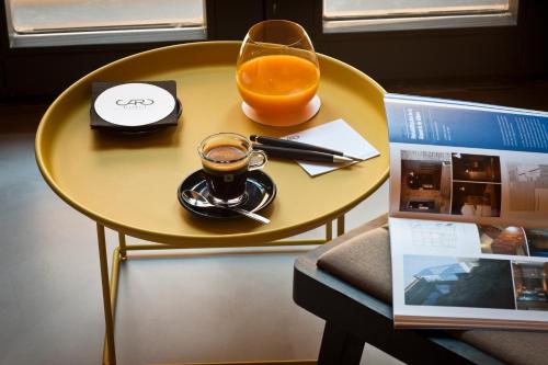 a yellow table with a cup of coffee and a glass of orange juice at Caro Hotel in Valencia