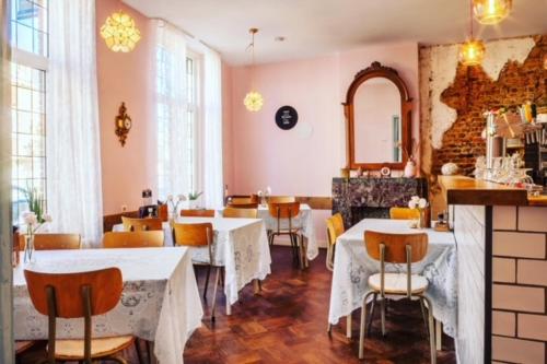 un restaurante con mesas, sillas y espejo en Blief bie de Mam, en Echt