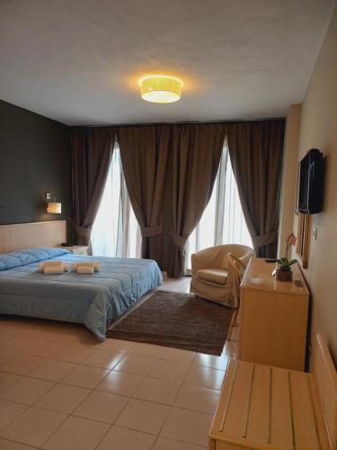 a bedroom with a bed and a chair and a television at River Park Hotel in Ameglia
