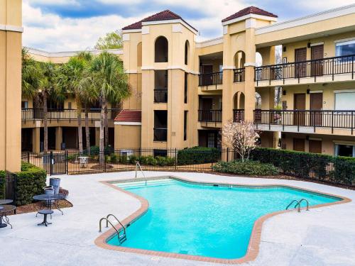 a swimming pool in the courtyard of a apartment building at Comfort Suites Baton Rouge South I-10 in Baton Rouge