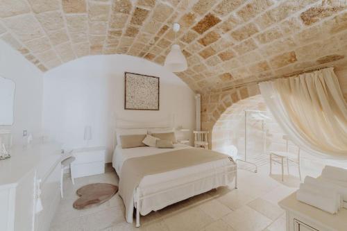 モノーポリにあるCasa Vacanza Portanuova Monopoli by MONHOLIDAYの石造りの天井のベッドルーム1室(白いベッド1台付)