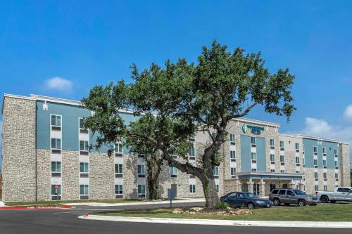 ジョージタウンにあるWoodSpring Suites Austin Georgetownの前に木がある大きな建物