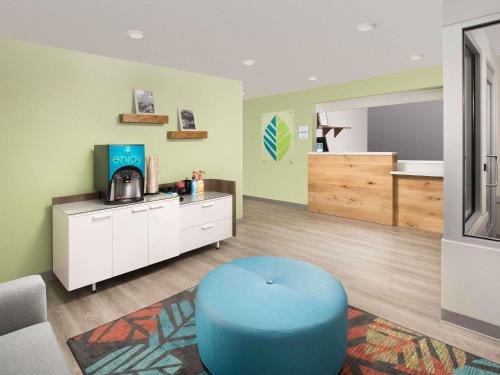 a living room with a blue ottoman and a sink at Candlewood Suites Pecos by IHG in Pecos