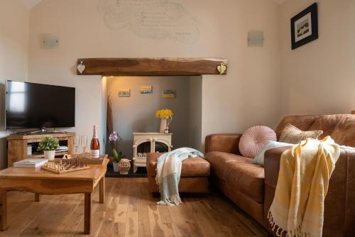 sala de estar con sofá y mesa en Beautiful Countryside cottage on the North Wales Coast en Abergele