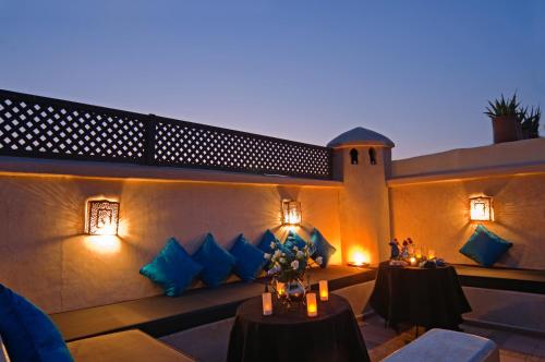 un patio con 2 mesas y almohadas azules en Riad Papillon by Marrakech Riad, en Marrakech