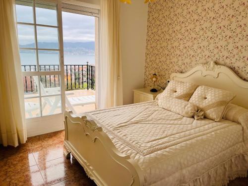 1 dormitorio con cama y ventana grande en Casa Loureiro Combarro, en Combarro