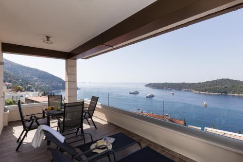 einen Balkon mit Stühlen und Blick auf das Wasser in der Unterkunft Amorino Of Dubrovnik Apartments in Dubrovnik