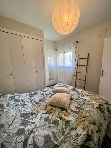 une chambre avec un grand lit avec une couverture colorée dans l'établissement Gîte La Fougère, à Vals-les-Bains