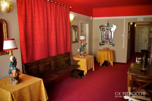 a living room with a red curtain and two tables at Ca' Pedrocchi in Venice