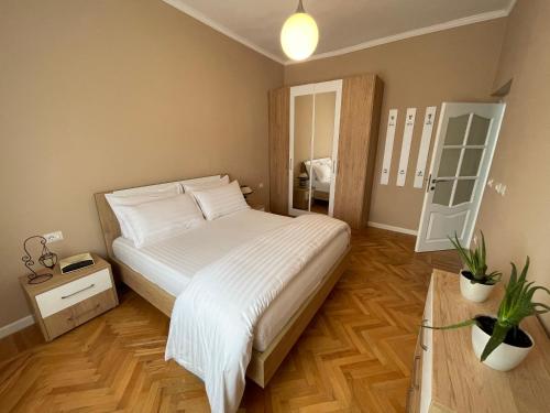 a bedroom with a large bed with white sheets at Joni & Joy Center Apartment in Berat