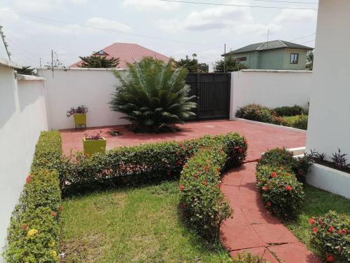 un jardín con arbustos y flores en un patio en Cheerful 2-bedroom Apartment with free parking, en Kumasi