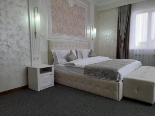 a hotel room with two beds and a window at Dora Hotel in Shymkent