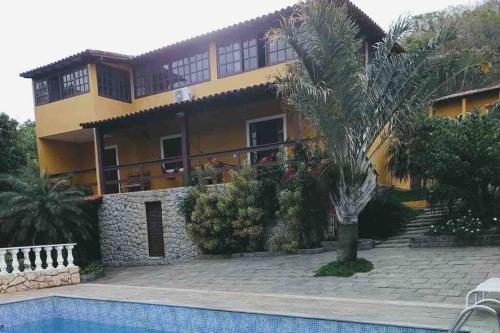 a house with a swimming pool in front of it at CASA SURYA, Piscina Fantástica, Churrasqueira, Completa, 18 HÓSPEDES na REGIÃO DOS LAGOS - Casa de Campo in Iguaba Grande