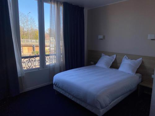 a bedroom with a bed and a large window at Appart' hôtel 7 sensation in Bougival