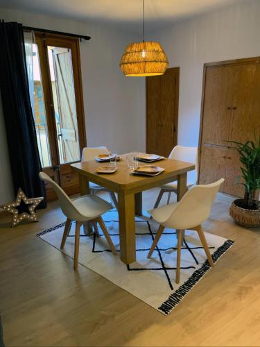 uma sala de jantar com uma mesa de madeira e cadeiras em Apartaments Albiñana em Llavorsí