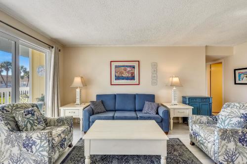ein Wohnzimmer mit einem blauen Sofa und Stühlen in der Unterkunft Sandpiper Cove 1082 Destin Condo in Destin