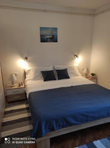 um quarto com uma cama grande e um cobertor azul em Kuća za odmor MANA em Lun