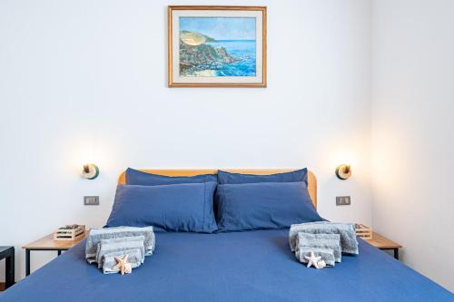 ein Schlafzimmer mit einem blauen Bett und Handtüchern darauf in der Unterkunft Casa Rinalmas FREE PARKING & WIFI in Castiglione della Pescaia